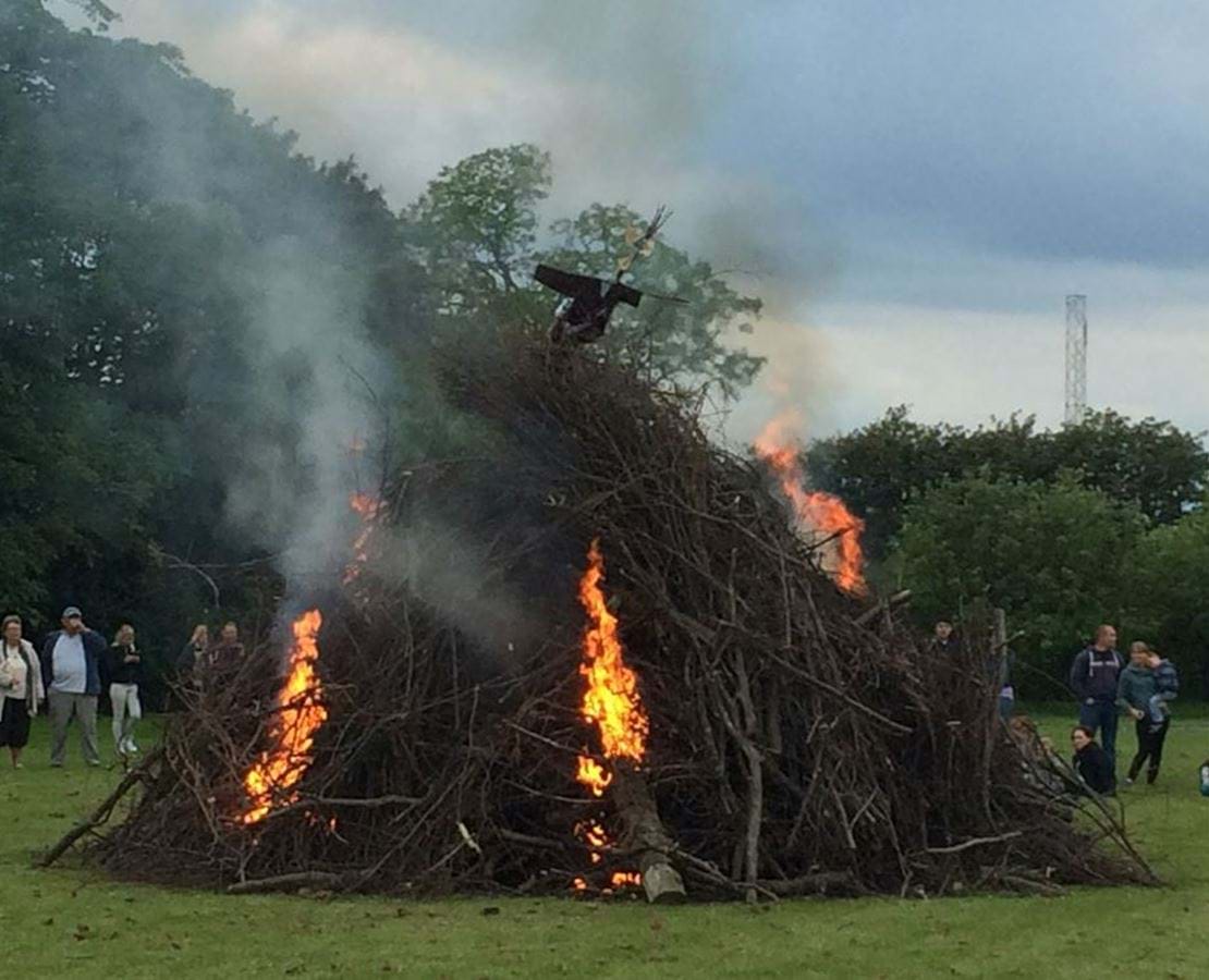 Stort Sankt hans bål med tilskuere. Det brænder 3 steder i bålet.